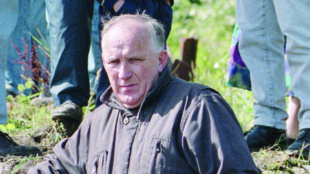 Father Patrick Ryan on a roadside, wearing a grey jacket. PA Images / Alamy Stock Photo