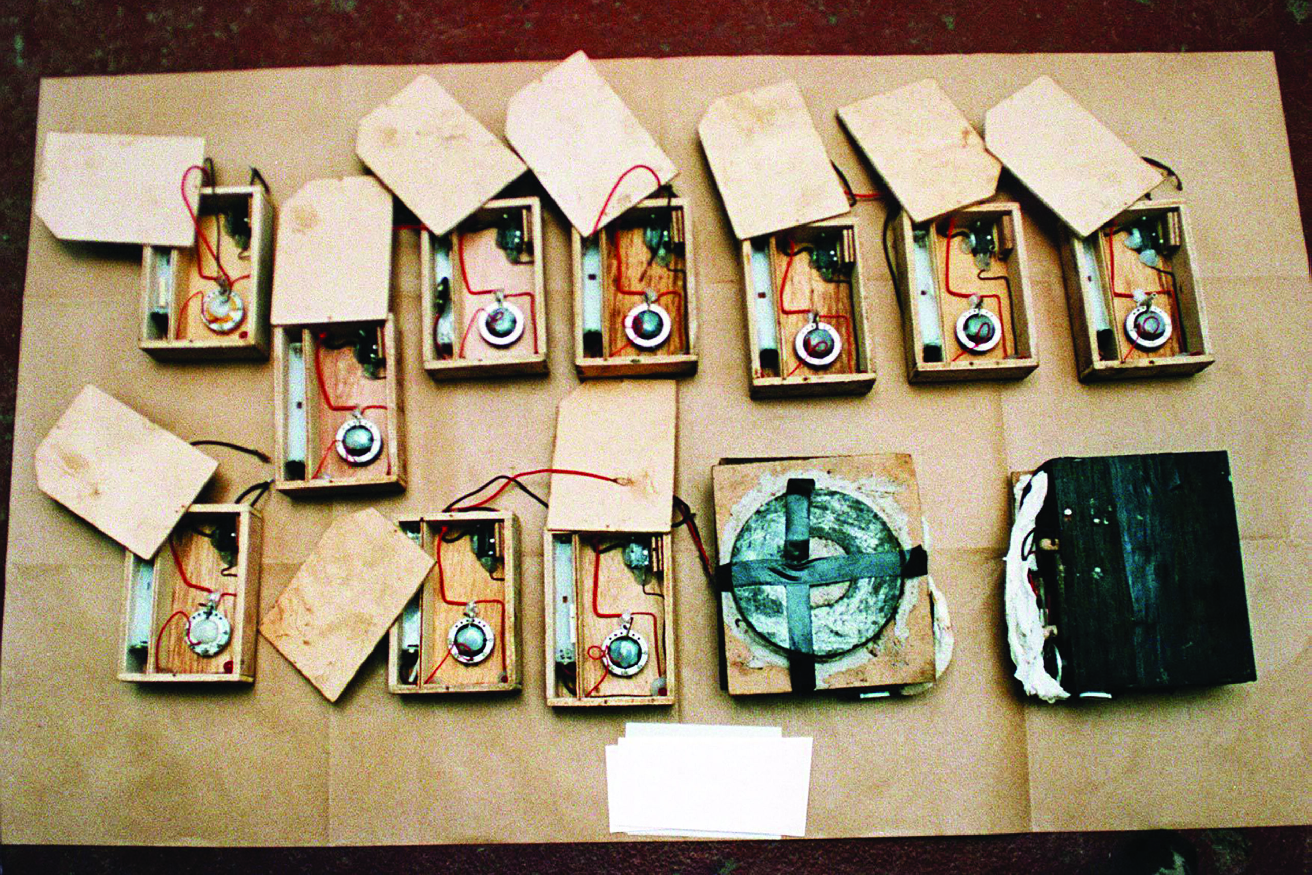 Two rows of Memo Park timers in open wooden boxes, wired for use in IRA bombs.